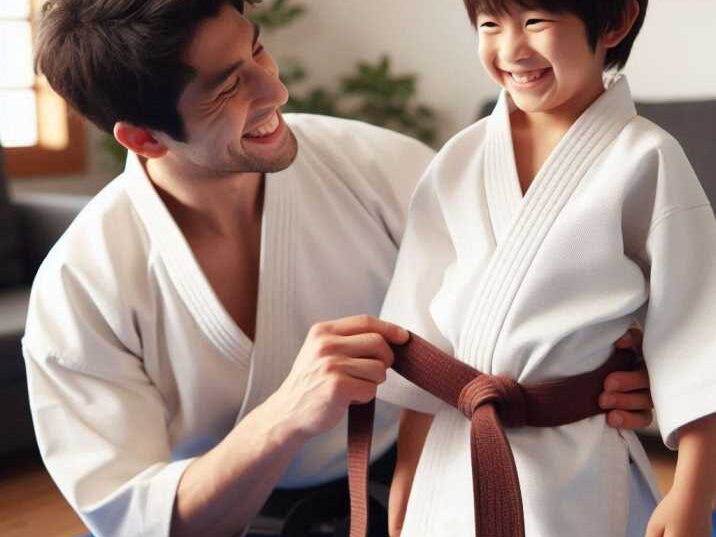 Child smiling and receiving a new belt from instructor